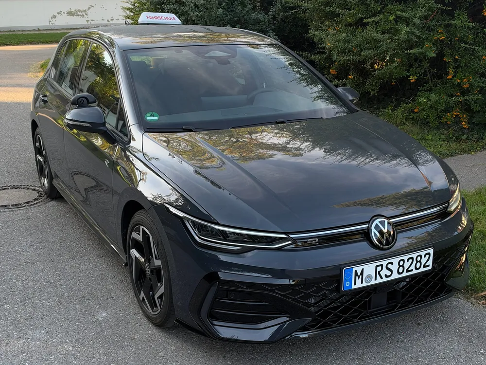 Der dunkelgraue VW Golf 8 mit Fahrschul-Dachschild, schräg von vorne